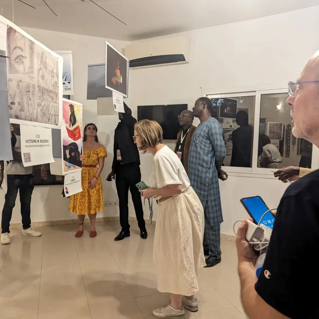 Visitors looking at the satirical cartoons on display at LomanArt